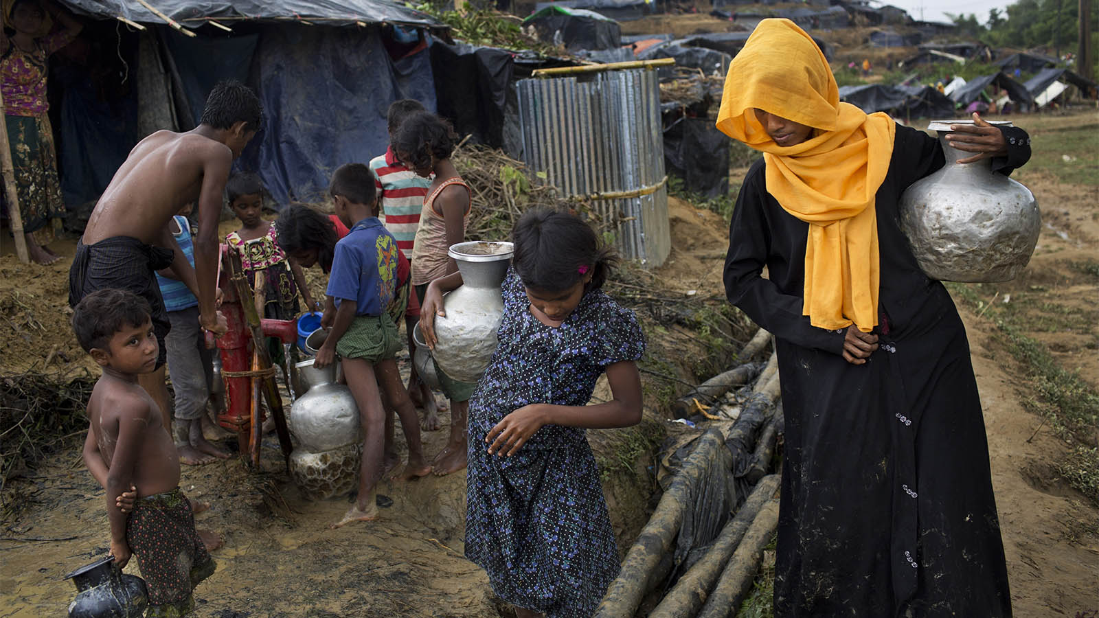משפחה ממיעוט הרוהינגיה שואבת מים מבאר במחנה פליטים בבנגלדש (צילום: AP Photo/Bernat Armangue)