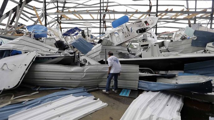 אדם מתבונן על ערית סירות שנוצרה בעקבות הוריקן הארווי, ב-27 באוגוסט 2017, טקסס. צילום: AP