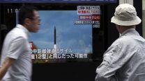 תושב יפן צופה בשיגור הטיל הצפון קוריאני  (AP Photo/Eugene Hoshiko)
