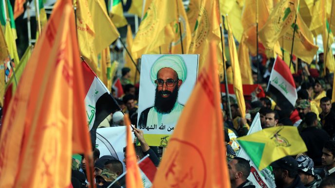 מיליציות שיעיות צועדות בבגדד עם דגלי שיעים ותמונות של השיח נימר אל נימר במחאה על הוצאתו להורג בערב הסעודית. 6 בינואר 2016 (צילום: AP Photo/Khalid Mohammed)