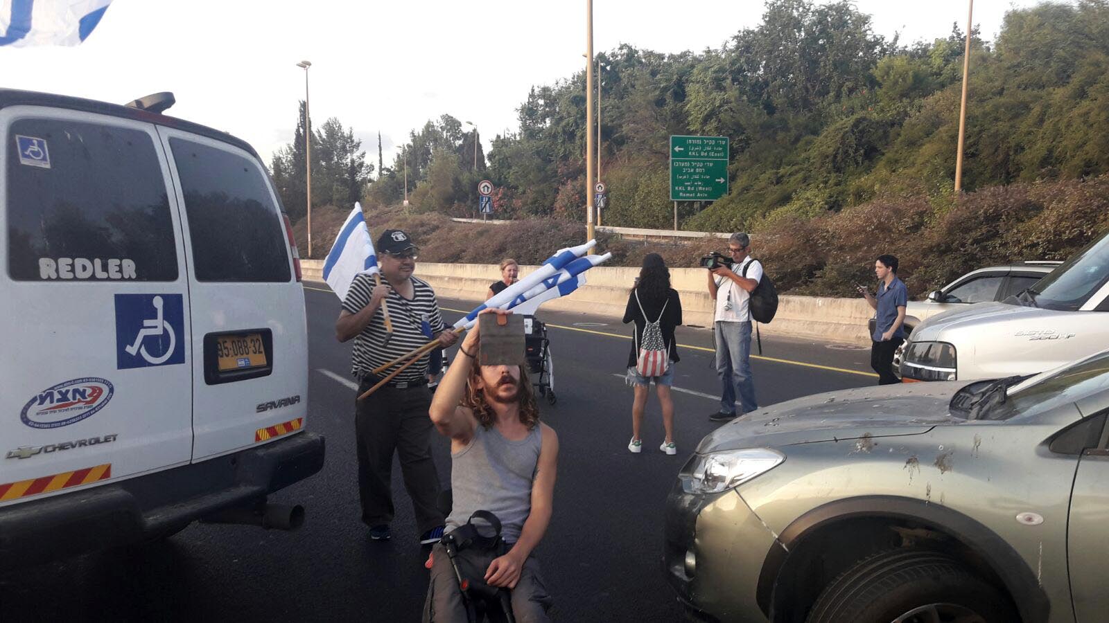 פעילי מאבק הנכים חוסמים את כביש איילון לכייוון דרום (צילום: הנכים הופכים לפנתרים)