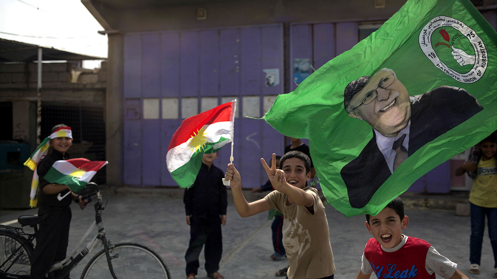 ילדים מניפים דגלים כורדים ברחובות קירקוק ביום משאל העם. (צילום: AP Photo/Bram Janssen).