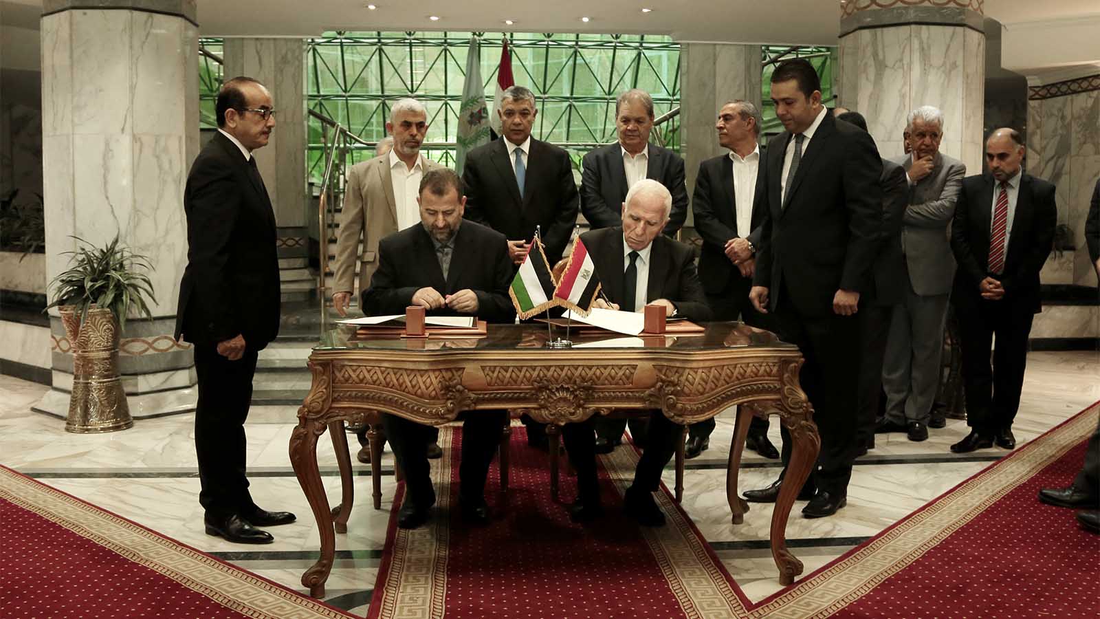 נציג פת&quot;ח עזאם אל אחמד ונציג חמאס סאלח אל ערורי חותמים על הסכם הפיוס בין חמאס לפת&quot;ח במצרים. 12 באוקטובר 2017 (צילום: AP Photo/Nariman El-Mofty)