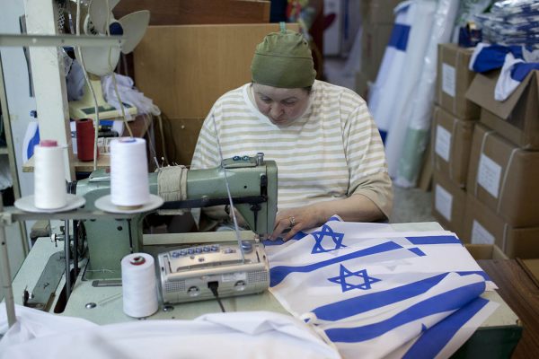 עובדת ישראלית תופרת דגל ישראל במפעל להכנת דגלים בירושלים. צילום ארכיון, למצולמת אין קשר לכתבה (צילום: יונתן זינדל/ פלאש 90)
