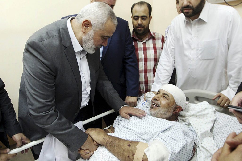 מנהיג הלשכה המדינית של החמאס איסמעיל הנייה מבקר את תאופיק אבו נעים בבית החולים, לאחר שנפצע בנסיון התנקשות, 27 באוקטובר (צילום: Mohammad Austaz, Hamas Media Office via AP)