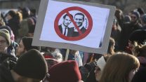 Protestors hold a poster with new Chancellor Sebastian Kern and new Vice Chancellor Heinz-Christian Strache at a demonstration during the swearing-in ceremony of the new Austrian government led by a conservative and a nationalist party in Vienna, Austria, Monday, Dec. 18, 2017. (AP Photo/Ronald Zak)