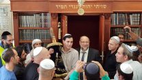 חיים הורוביץ, בנו של המנכ"ל לשעבר אלי הוריביץ ז"ל, מחזיק בספר התורה לפני הכנסתו לארון הקודש בבית הכנסת החדש באתר (קרדיט: לירן קדושים)