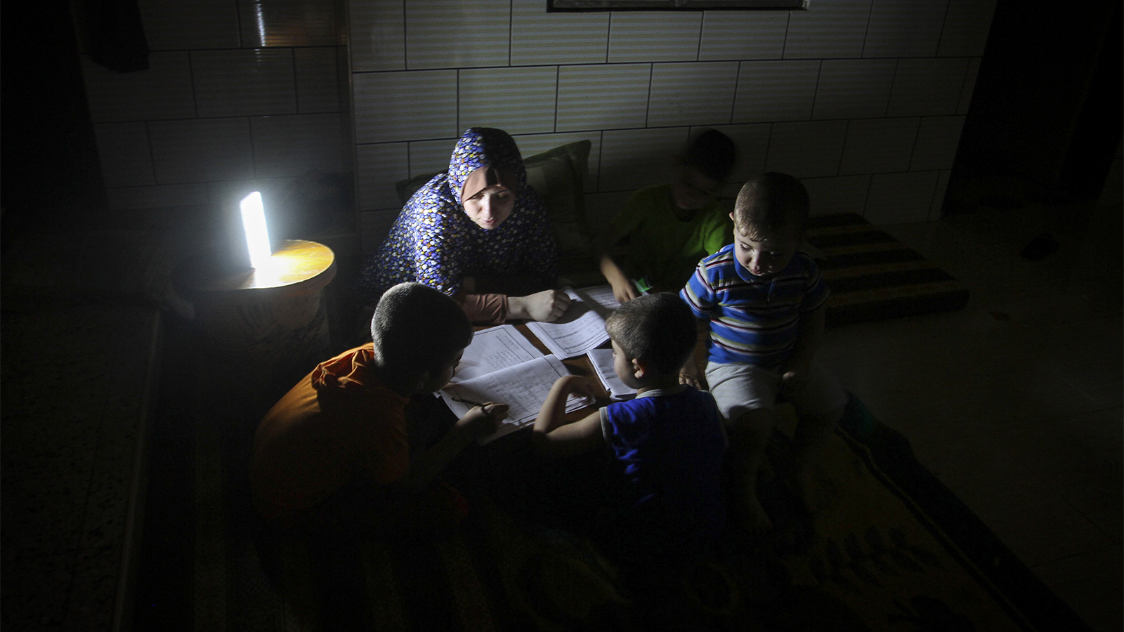 משפחה פלסטינית בחשכה, בעקבות הפסקת חשמל ברפיח (צילום: עבד רחים כתיב / פלאש 90).