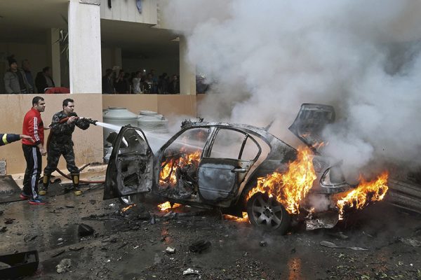 לוחמי אש לבנוניים מכבים מכונית בוערת שפוצצה בצידון (צילום: AP Photo/Mohammed Zaatari).