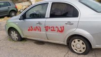 ריסוס כתובות באמצעות ספריי צבע על מספר כלי רכב חונים בכניסה לכפר בית איכסא. (צילום: דוברות המשטרה)