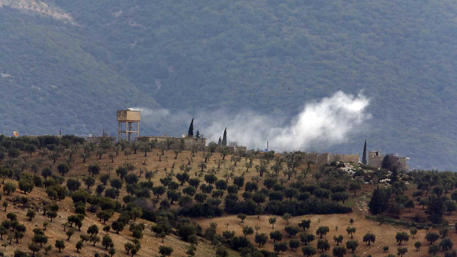 עשן מיתמר מעל כפר בפאתי סוריה, בתוך תחומי המובלעת עפרין, לאחר הפגזה של הצבא הטורקי. התמונה צולמה ב-21 לינואר משטח טורקיה. (AP Photo/Lefteris Pitarakis)