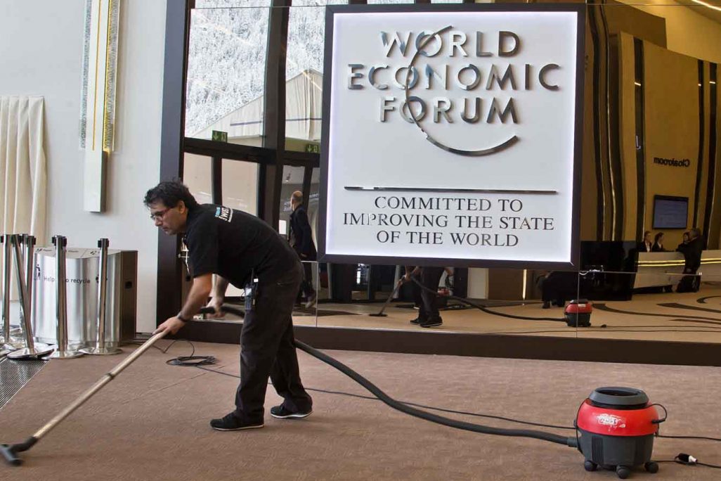 עובד ניקיון מנקה את אולם הכנסים בדאבוס לקראת כנס הכלכלה העולמי , ינואר 2018(AP Photo/Michel Euler)