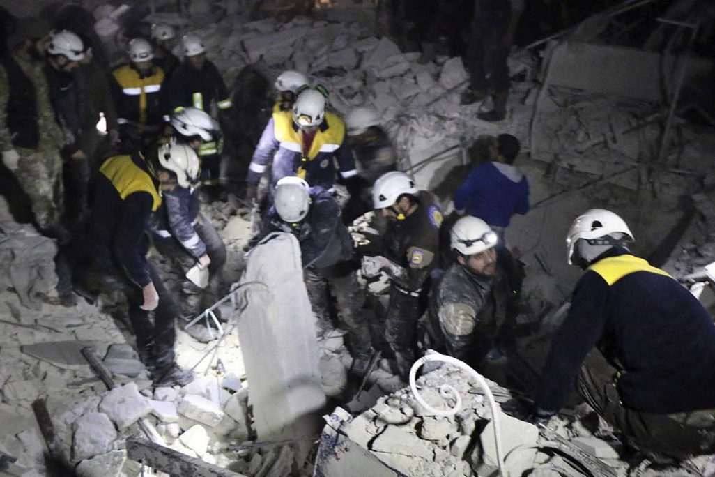 כוחות ההגנה האזרחית 'הקסדות הלבנות' מפנים פצועים בניין שהופצץ בעיר אדליב 7 בינואר 2018 (צילום: Syrian Civil Defense White Helmets via AP)