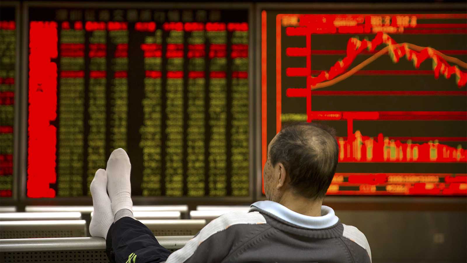 סוכן השקעות סיני עוקב אחר התפתחויות בבורסה בבייג'ינג (AP Photo/Mark Schiefelbein)