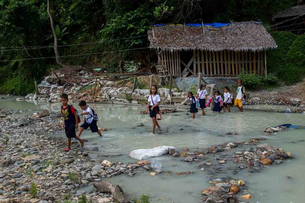 ילדים חוצים נהר מזוהם בדרך לבית הספר, בפיליפנים (צילום: Mark Z. Saludes for Human Rights Watch)