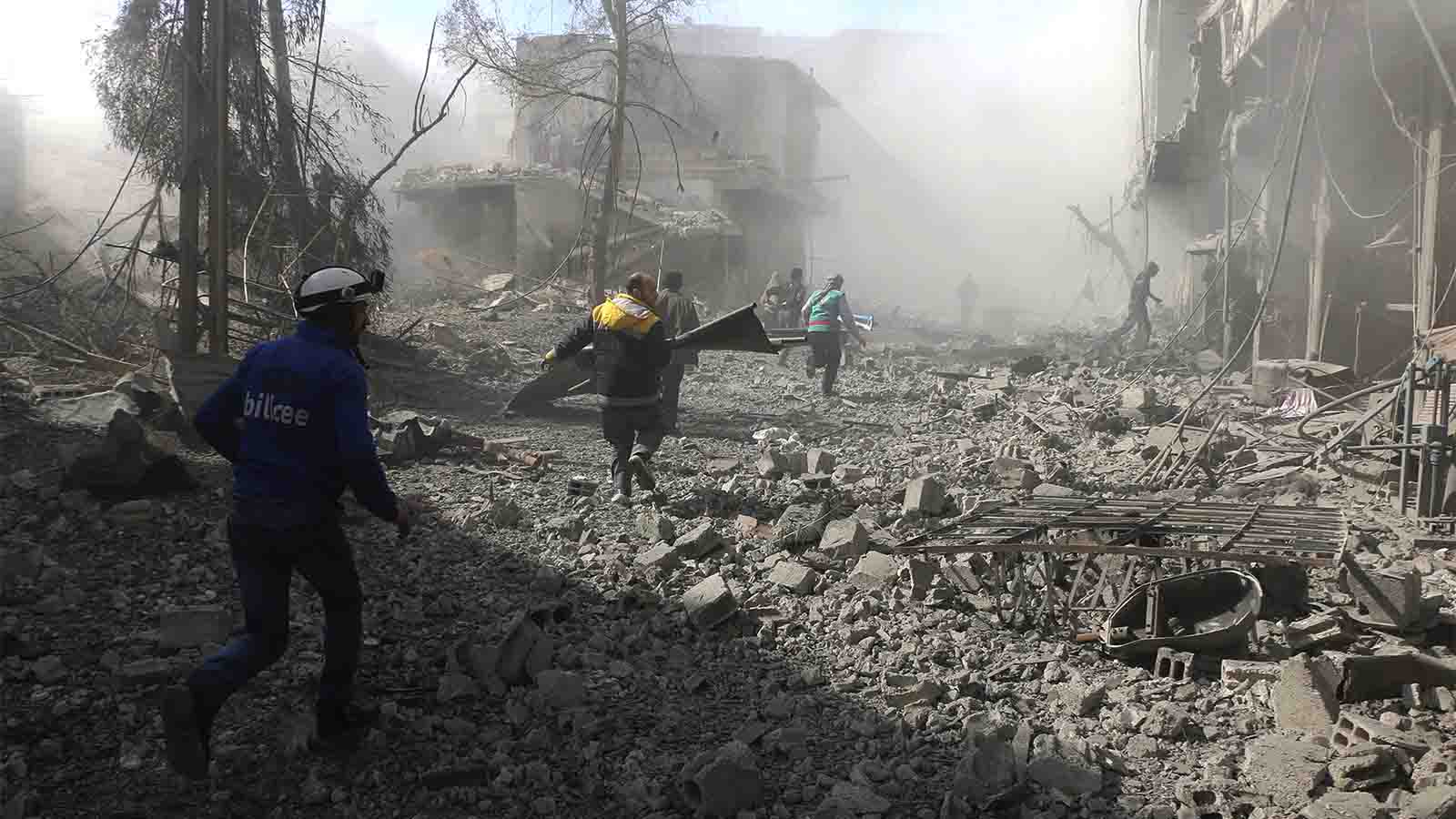 אנשי ארגון 'הקסדות הלבנות' רצים לחלץ נפגעים מבניין שהתמוטט בעוטא בפרברי דמשק, לאחר בהפצצות אויריות של צבא סוריה. 20 בפברואר (צילום: Syrian Civil Defense White Helmets via AP)
