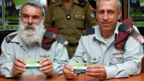 הרב הראשי לצה"ל לשעבר אביחי רונצקי (משמאל) חותם על כרטיס אד"י עם נתן אש קצין רפואה ראשי בצה"ל,
 2009 (צילםו: דו"צ)