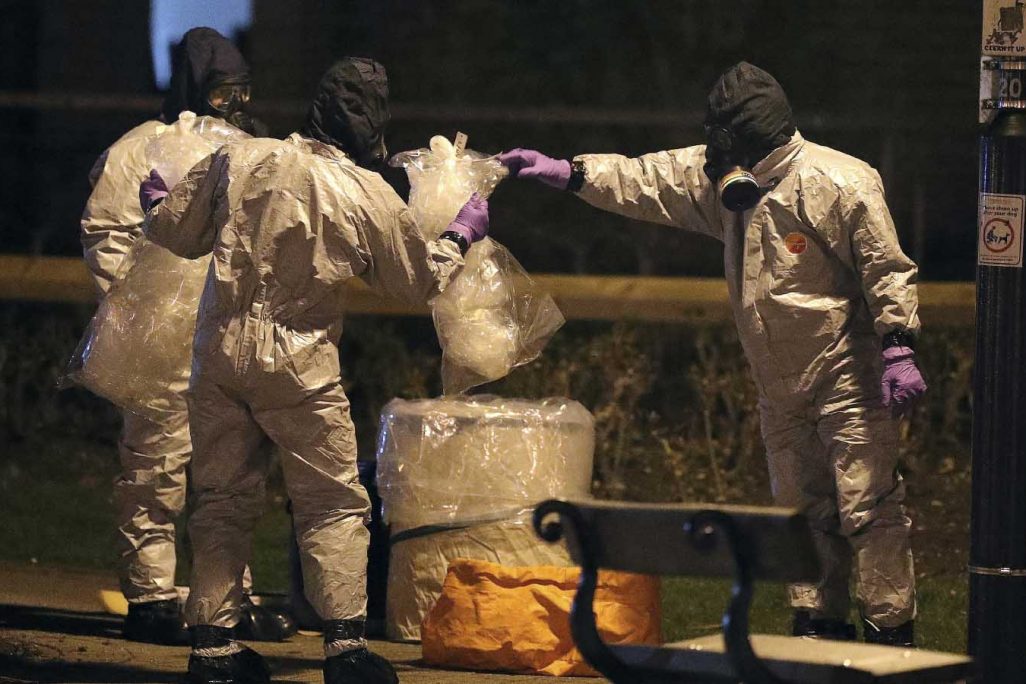 חוקרים בריטים לבושים בחליפות מגן בודקים את זירת ניסיון הרצח (Andrew Matthews/PA via AP)
