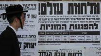 חרדי במאה שערים עובר מול פשקוויל הקורא להפגנות המוניות עקב מעצרים של חרדים שהשתמטו משירות צבאי. ארכיון (צילום: נתי שוחט/ פלאש90)