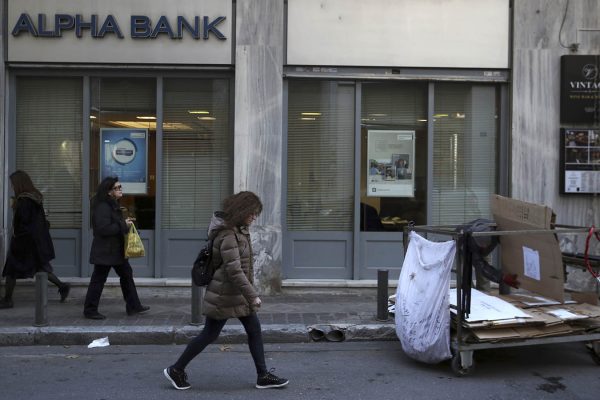 אדם אוסף קרטונים מחוץ לבנק באתונה, יוון 2 בפרואר 2018 (AP Photo/Thanassis Stavrakis)
