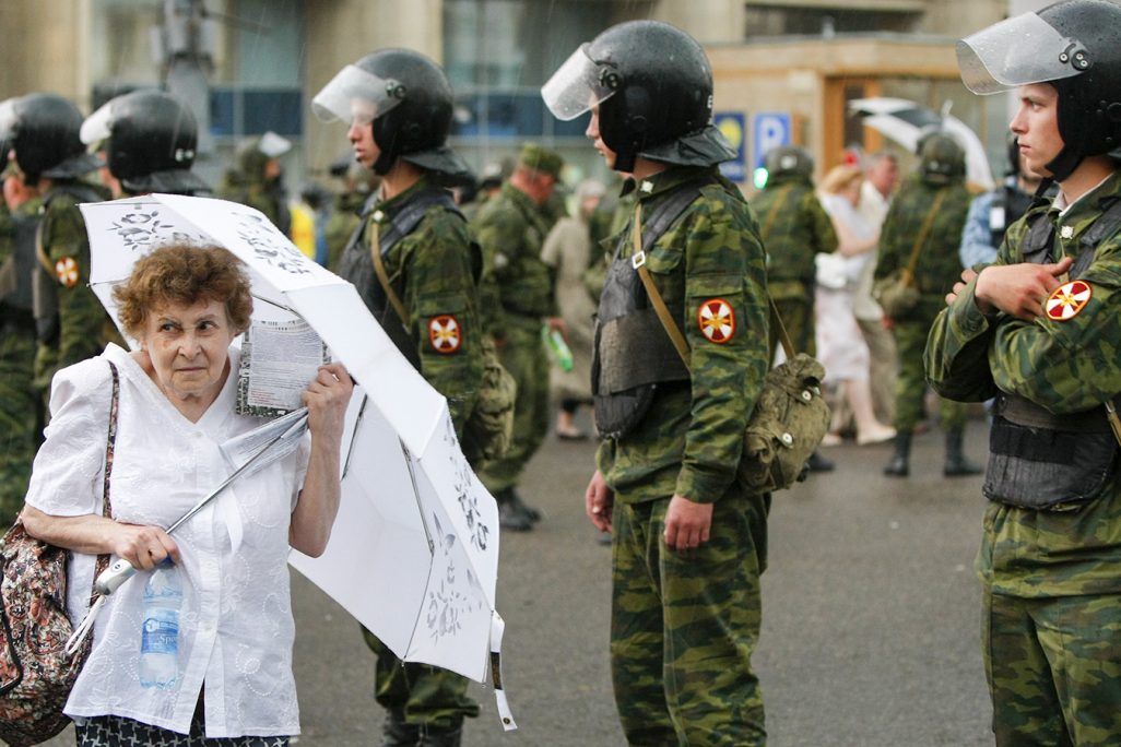 אשה מבוגרת הולכת לפני שוטרים בהפגנת האופוזיציה במוסקבה ביוני 2012 (צילום: AP Photo/Alexander Zemlianichenko).