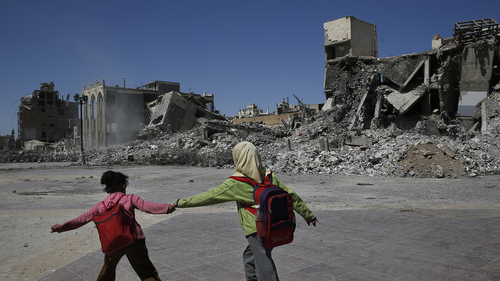ילדים ליד חורבות בעיר רקה שבסוריה (צילום: AP Photo/Hussein Malla).