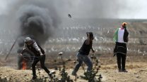 עזתים מיידים אבנים בהפגנות מול גדר הגבול בעזה 13 באפריל (AP Photo/ Khalil Hamra)