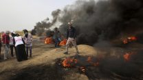 עזתים מיידים אבנים ושורפים צמיגים בהפגנות מול גדר הגבול. 20 באפריל (AP Photo/ Adel Hana)