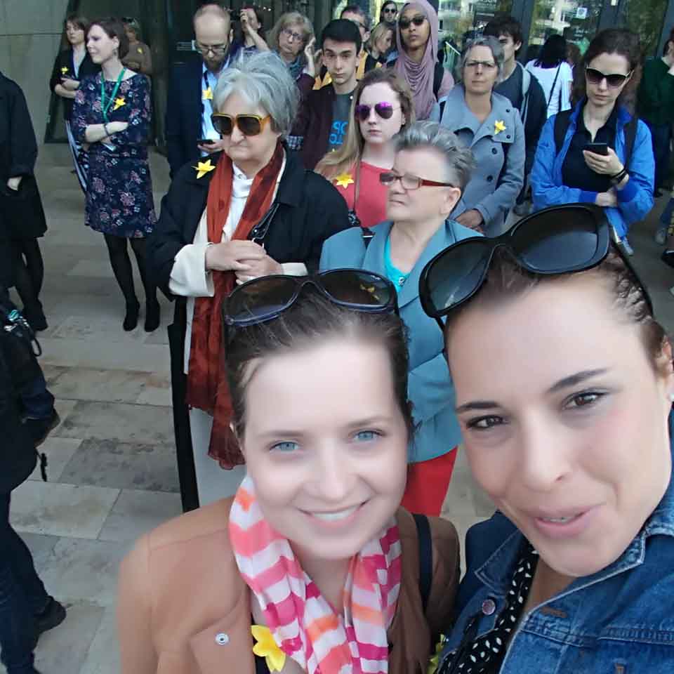 דניאלה סינגר (מימין) בפולין. מאחוריה קהל העונד נרקיס צהוב סמלי, כחלק ממסורת הנהוגה בפולין לציון מרד גטו ורשה. (התמונה באדיבות המצולמת)