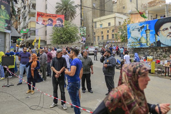 כרזות המראות את תמונתו של חסן נסראללה תלויות מחוץ למרכזי הצבעה בזמן הבחירות בלבנון. חיזבאללה צפויה להגביר את כוחה בפרלמנט הלבנוני. (AP Photo/Hassan Ammar)
