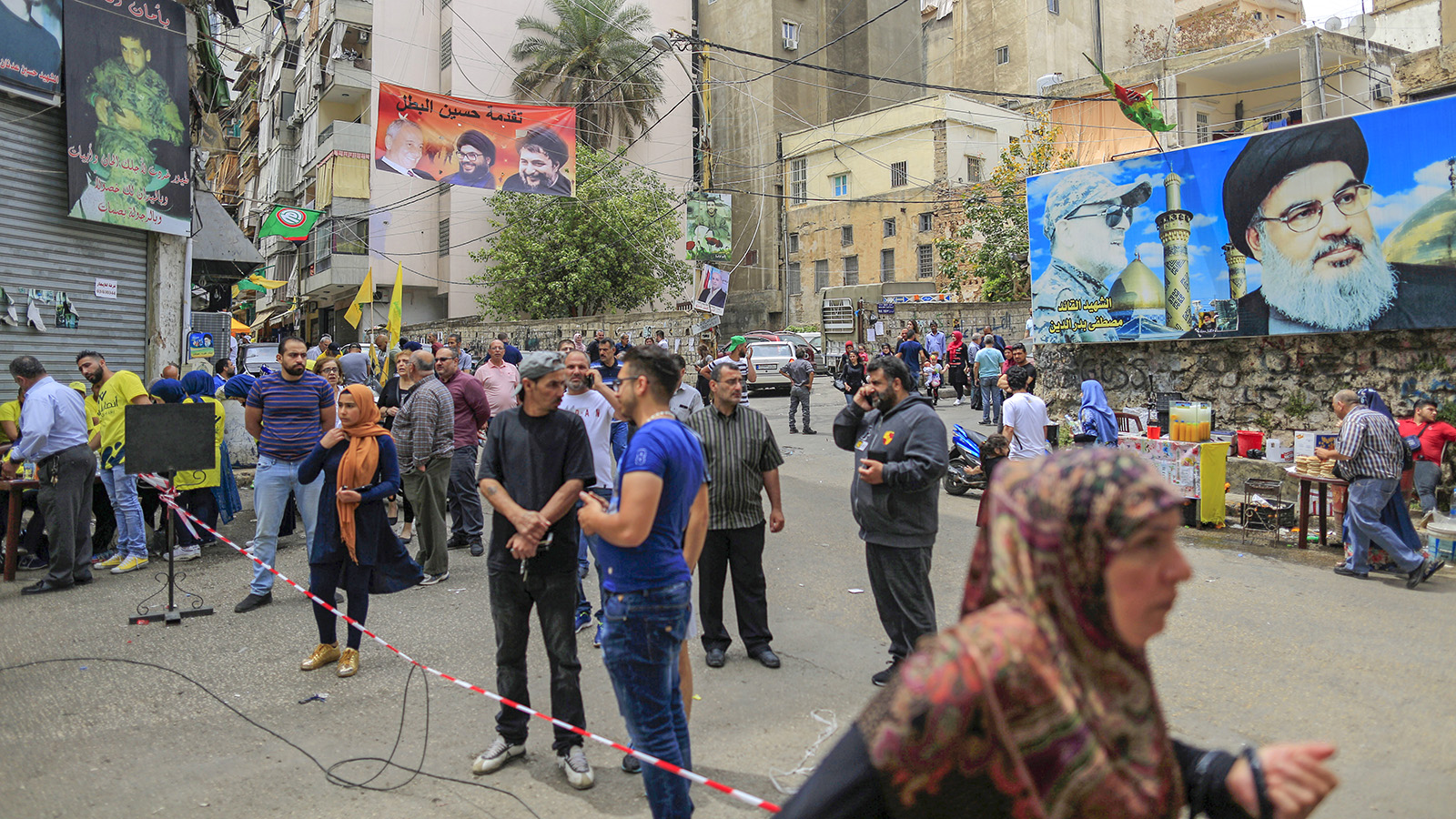 כרזות המראות את תמונתו של חסן נסראללה תלויות מחוץ למרכזי הצבעה בזמן הבחירות בלבנון. חיזבאללה צפויה להגביר את כוחה בפרלמנט הלבנוני. (AP Photo/Hassan Ammar)