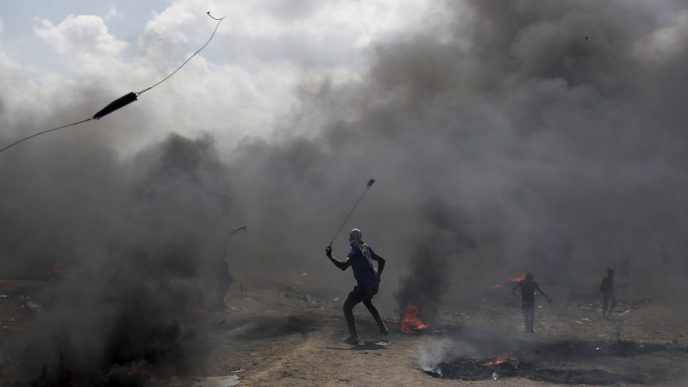 פלסטינים מתעמתים עם כוחות הביטחון בגבול רצועת עזה. 14 במאי (AP Photo/Khalil Hamra)