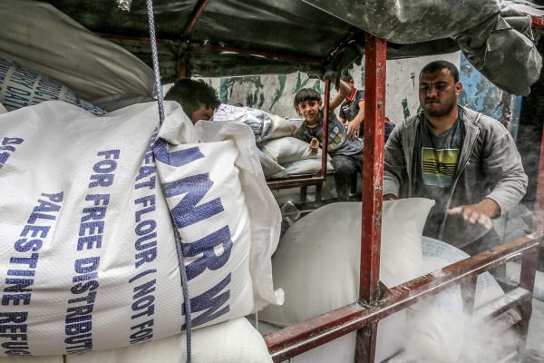 פלסטינים מקבלים את מנת המזון החודשית במרכז הסיוע של אונר"א ברפיח, 8 במאי 2018 ( Abed Rahim Khatib/Flash90)