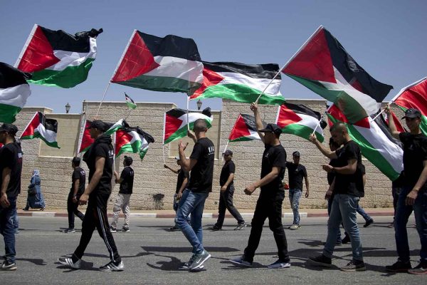 צעירים צועדים ברמאללה עם דגלי פלסטין, לציון יום הנכבה (צילום ארכיון: AP Photo/Majdi Mohammed)