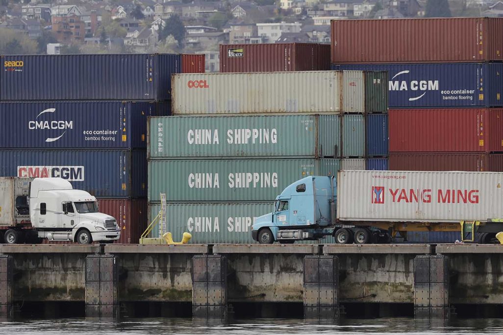 משאיות בנמל סיאטל פורקות מכולות מסין. אפריל 2018 (AP Photo/Ted S. Warren)