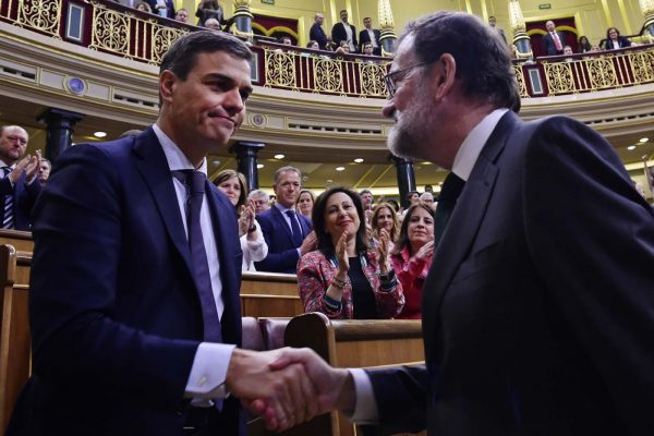 ראש ממשלת ספרד מריאנו ראחוי (מימין) לוחץ את ידו של פדרו סנצ'ז שנבחר להחליפו בעקבות הצבעת אי אמון בפרלמנט במדריד, 1 ביוני 2018 (Pierre Phillipe Marcou/Pool Photo via AP)