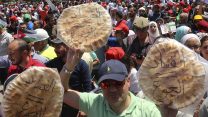 מפגינים בעמאן, מניפים פיתות עם הכיתוב "שחיתות שווה רעב" (צילום: (AP Photo/Raad al-Adayleh).