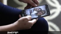 לידיה קארין סוזה, שביקשה מקלט מדיני בארה"ב, מסתכלת על תמונות של בנה דיוגו שנלקח ממנה בגבול מקסיקו-ארה"ב בחודש מאי. (צילום: (AP Photo/Charles Rex Arbogast