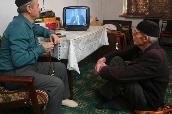 פנסיונרים רוסים צופים בנאום של פוטין בטלוויזיה. ארכיון (AP Photo/Musa Sadulayev)