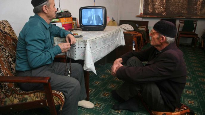 פנסיונרים רוסים צופים בנאום של פוטין בטלוויזיה. ארכיון (AP Photo/Musa Sadulayev)