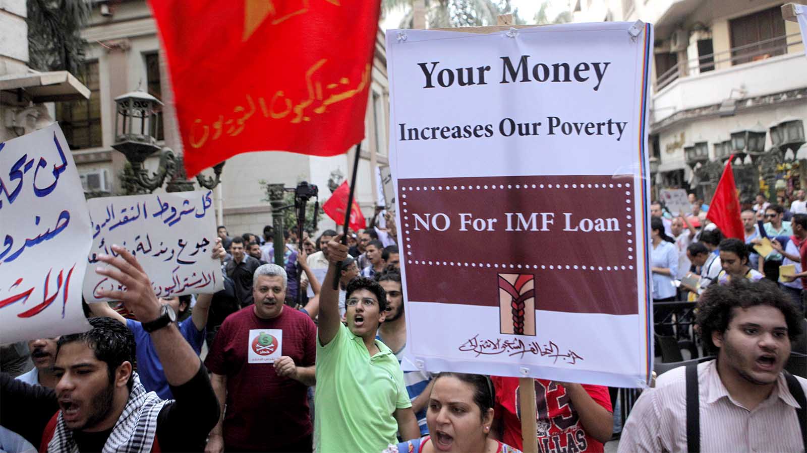 مواطنون مصريون يتظاهرون في القاهرة ضد صندوق النقد الدولي وسياسة إقراضها، بعد أن طلبت مصر من الصندوق قرض في آب 2012 (AP Photo/Amr Nabil)