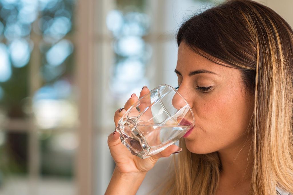אישה שותה מים (צילום אילוסטרציה: Shutterstock).