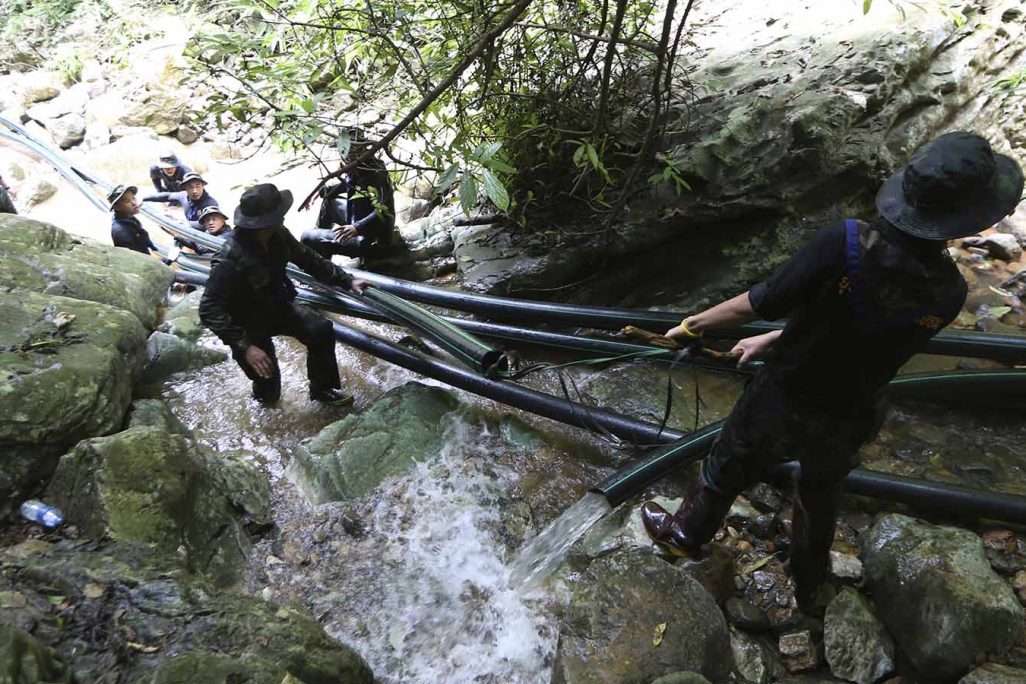 חיילים מניחים צינורות למנוע את הצפת המערה בה נמצאים הלכודים (AP Photo/Sakchai Lalit)