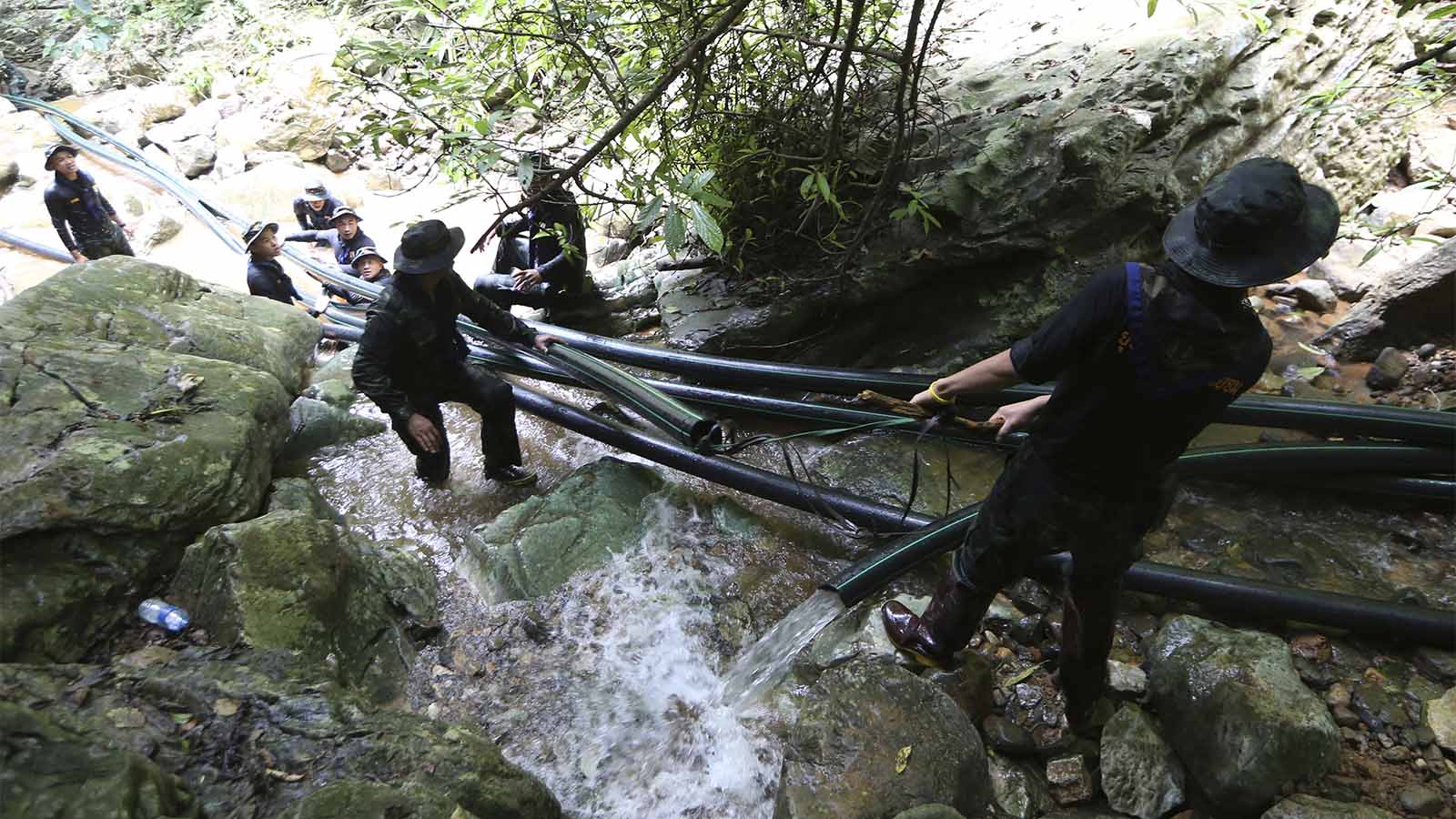 חיילים מניחים צינורות למנוע את הצפת המערה בה נמצאים הלכודים (AP Photo/Sakchai Lalit)