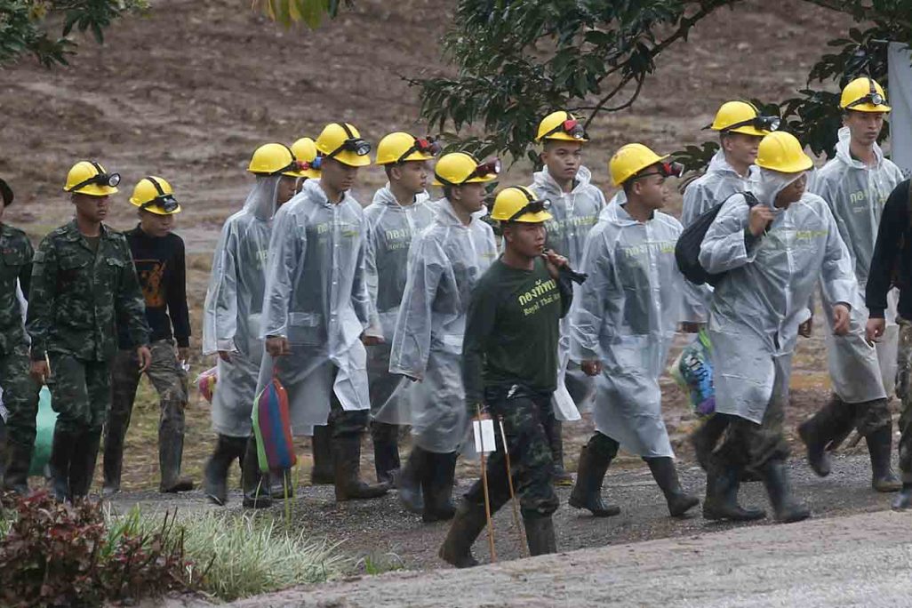 אנשי כוחות החילוץ צועדים לעבר פתח המערה בשעה שארבעת הנערים והמאמן שלהם עדיין היו לכודים. 10 ביולי 2018 (AP Photo/Sakchai Lalit)