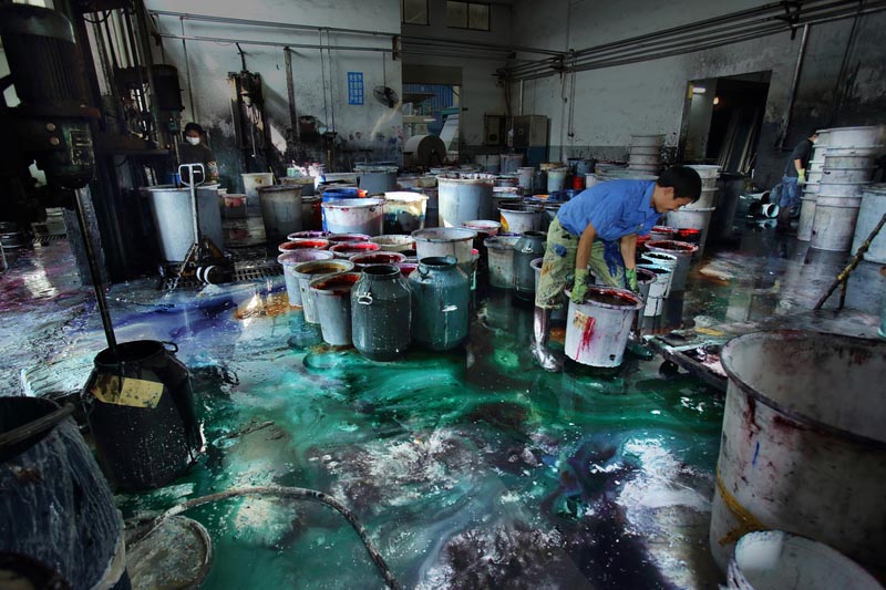 עובד צובע בדים במפעל באזור תעשייתי בסין. מאי 2012 (צילום: Lu Guang / Greenpeace)