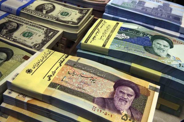 שטרות של ריאל איראני ודולר אמריקאי בדוכן החלפות כספים בטהרן (AP Photo/Vahid Salemi)