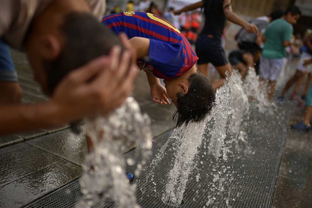 ילדים בספרד מתקררים במזרקה בעקבות גל החום הפוקד את אירופה. 4 באוגוסט 2018 (AP Photo/Alvaro Barrientos)