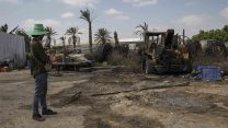 עובד תאילנדי מסתכל על הנזק שגרמה רקטה ששוגרה מעזה. 9 באוגוסט 2018 (AP Photo/Tsafrir Abayov)