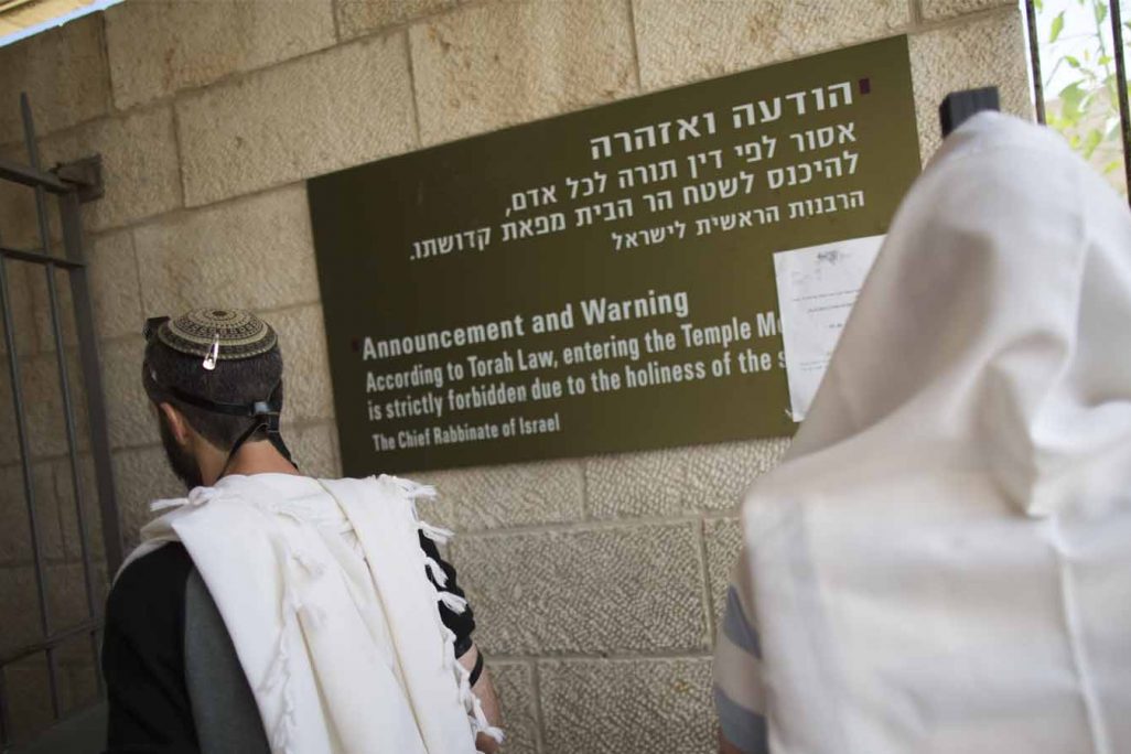 יהודים מתפללים מחוץ לכניסה להר הבית בסמוך לשלט האוסר על תפילה בו. (צילום ארכיון: יונתן זינדל/פלאש90)